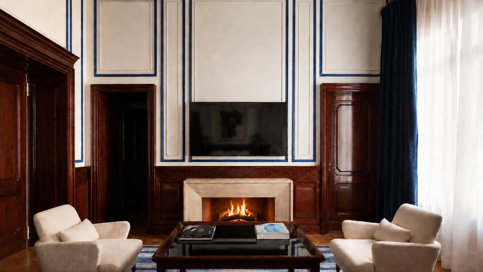 The living room — paneled fireplace wall, navy trim, and custom Murano chandelier